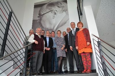 Andreas Stoch mit Geschäftsführer Beckh (3.v.r.) vor dem Foto des Firmengründers Max Schlatterer