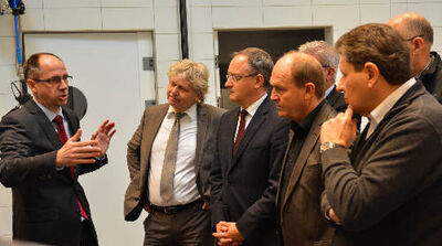 Achim Holz (li) führt Bürgermeister Bereska (2.v.l) und Andreas Stoch (3.v.l.) durch seine Firma.